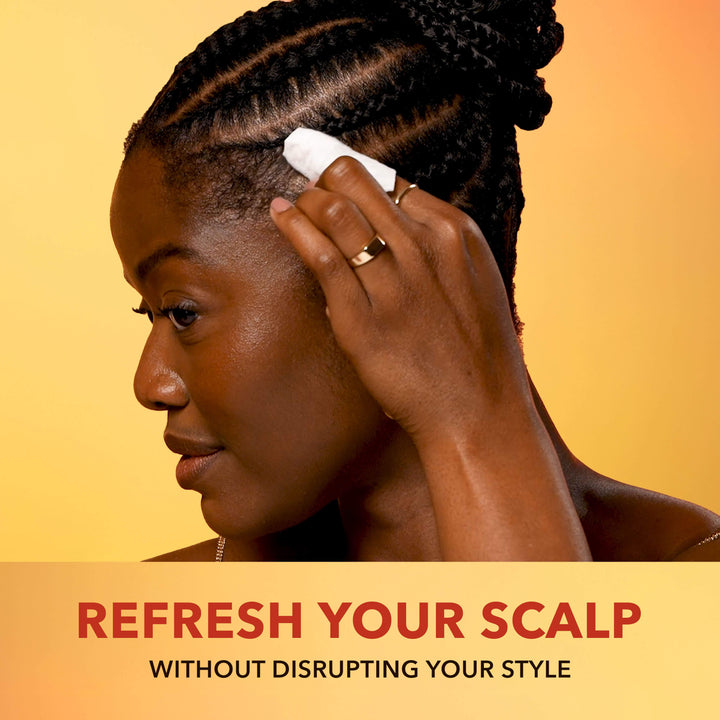Wemi Ahunamba applying a Scalp Relief Wipe to her scalp with text 'Refresh Your Scalp Without Disrupting Your Style' on a yellow background